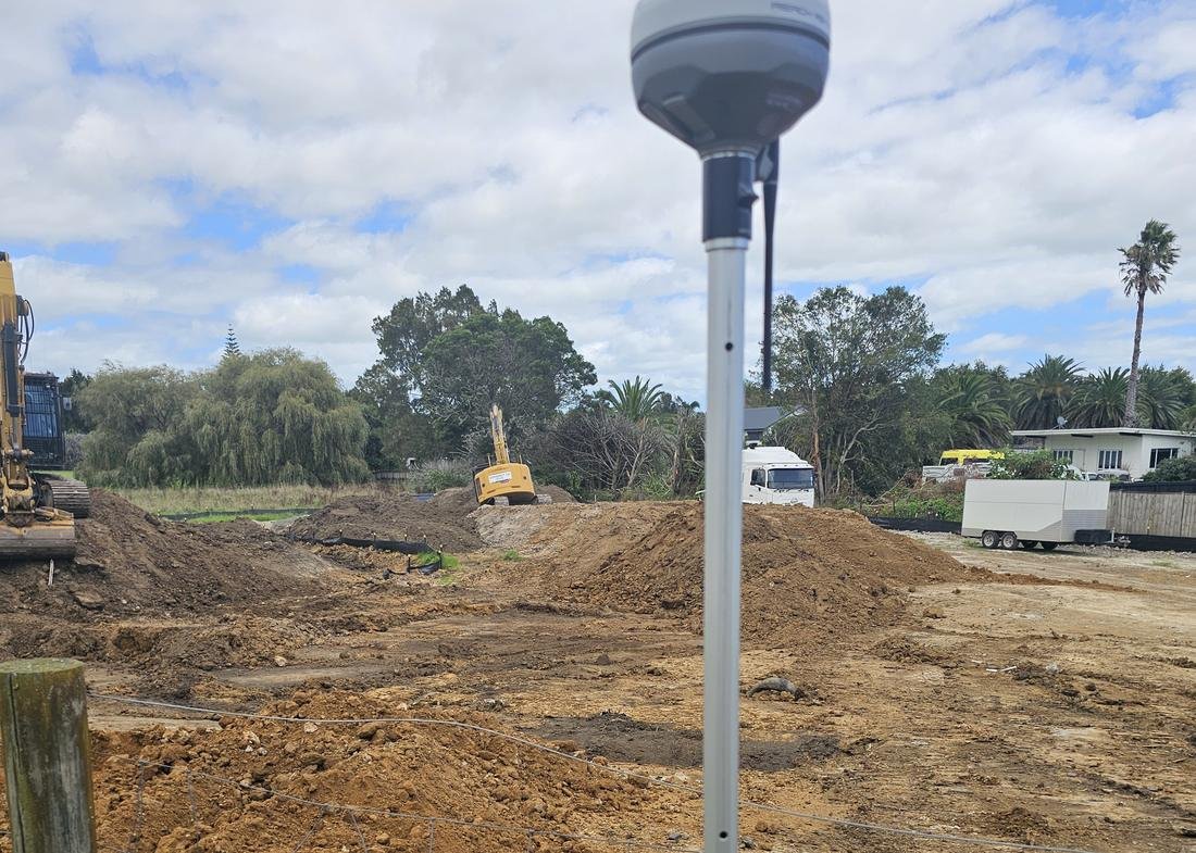 Emlid GNSS receiver on a rover pole at an earthworks site