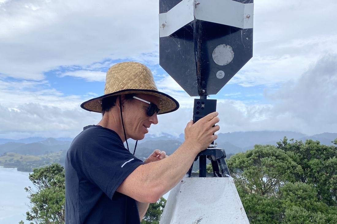 Surveyor observing at a geodetic trig beacon