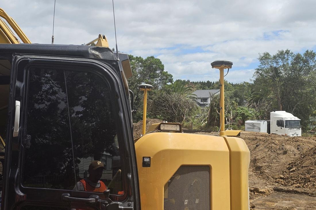 Excavator fitted with GNSS machine control on an Auckland site
